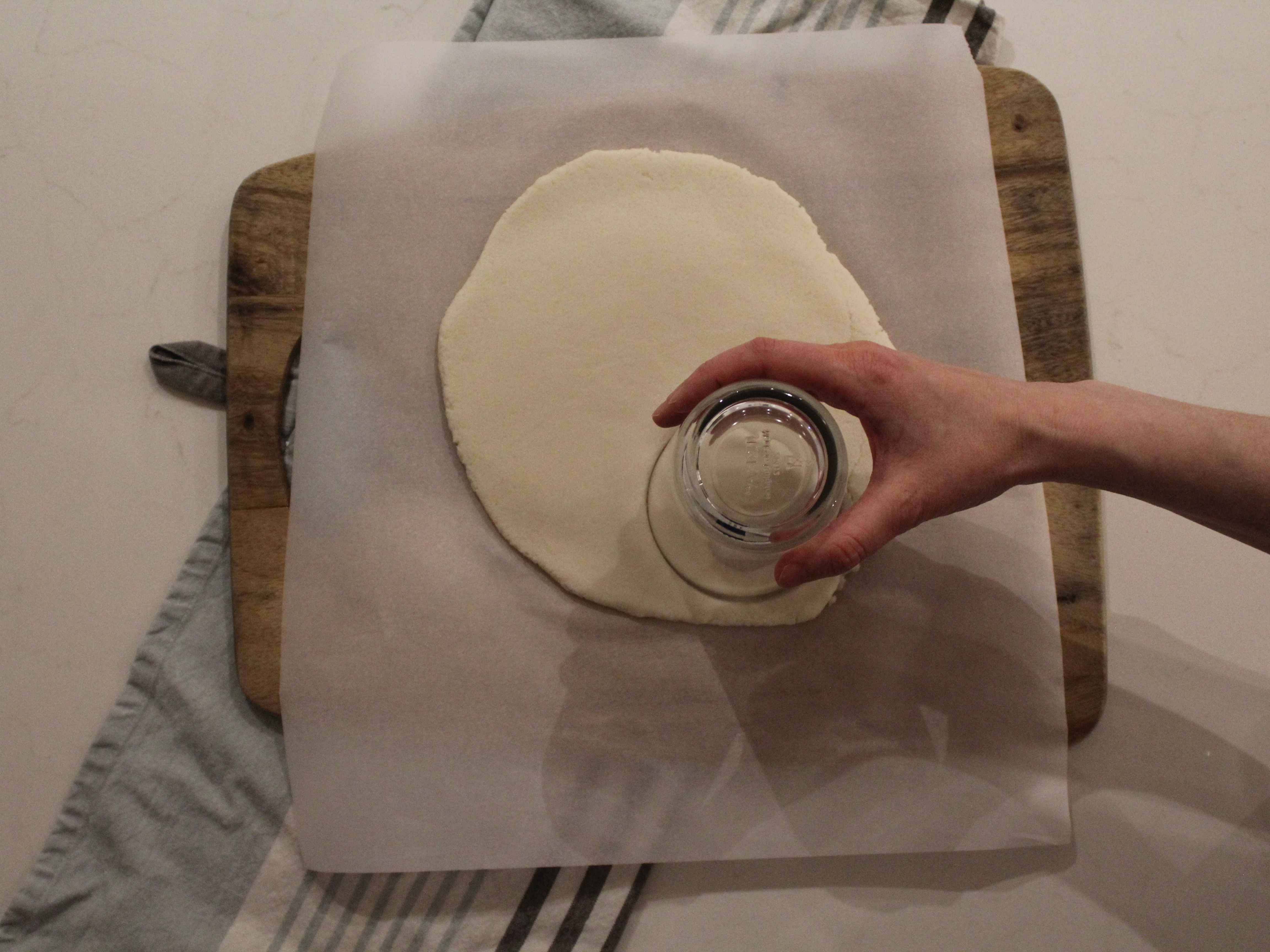 Cutting circles out of a dough using a glass for paw print