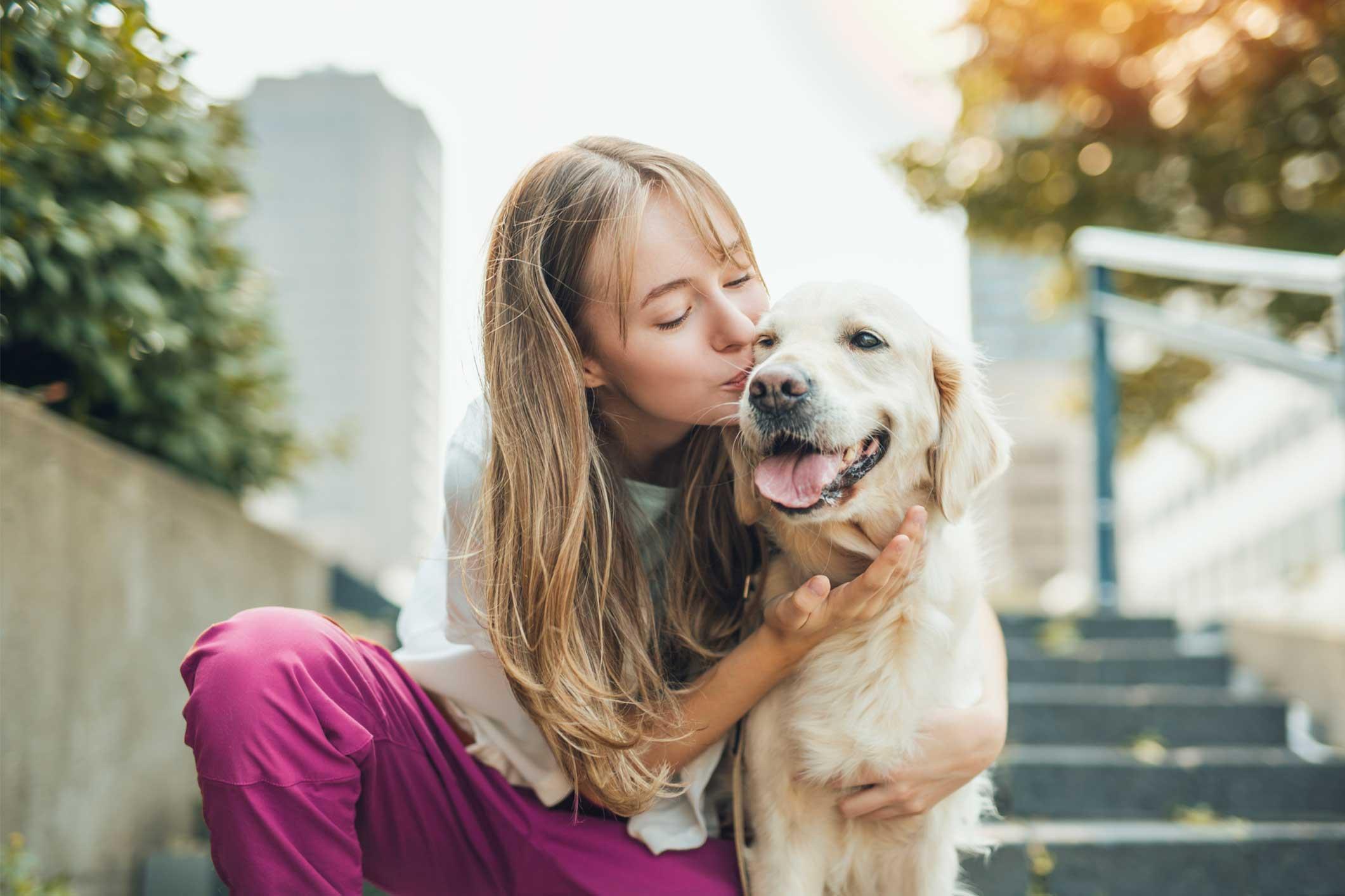 Young girl sitting outside with golden retriever