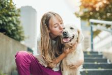 Young girl sitting outside with golden retriever