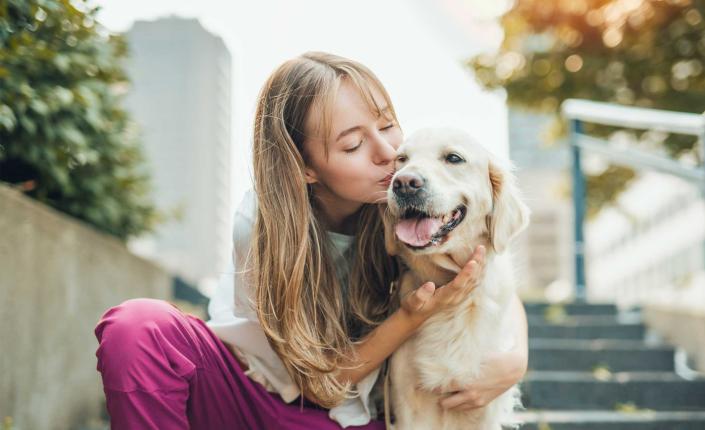 Young girl sitting outside with golden retriever